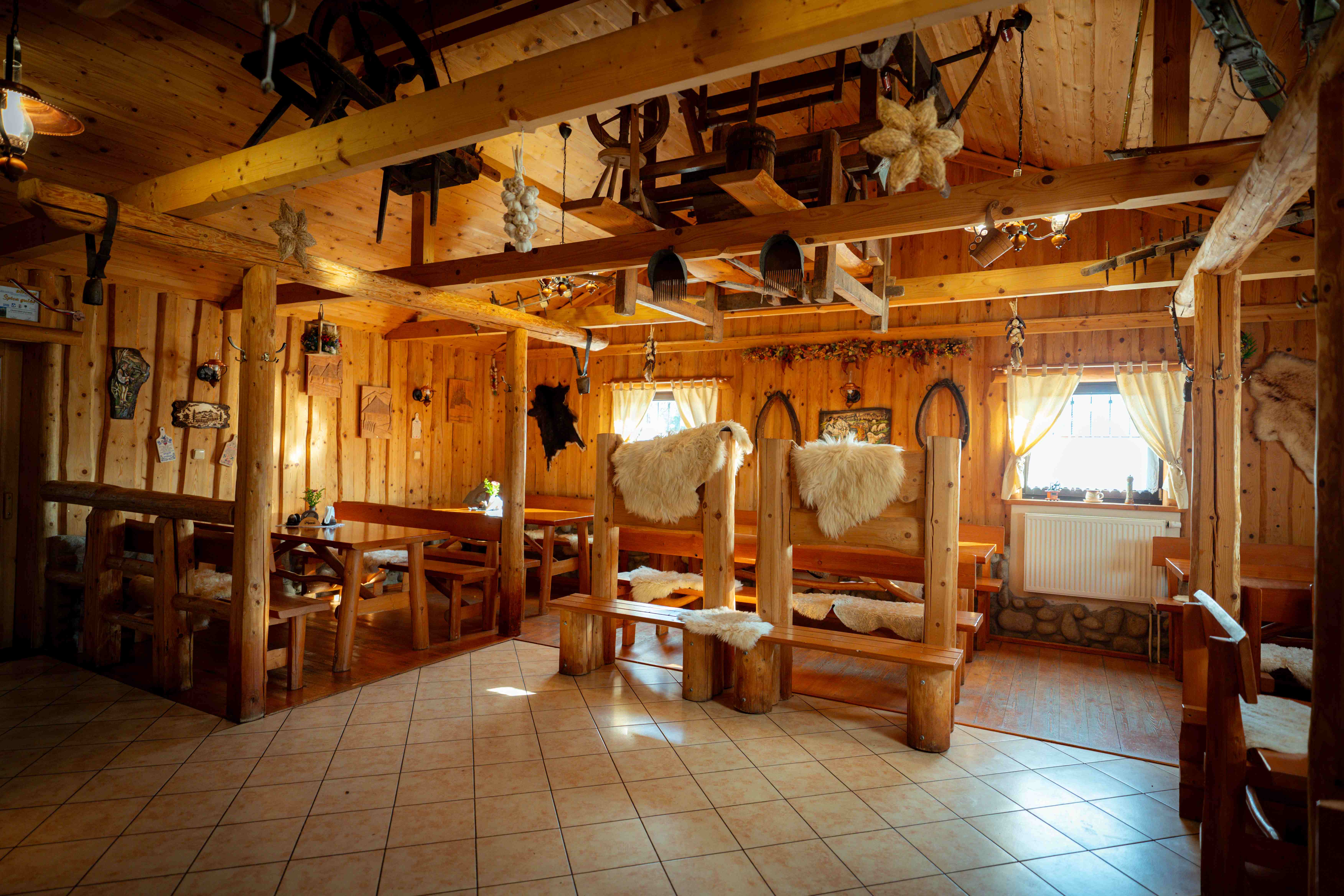 Interiér reštaurácie - drevené lavice s ovčími kožami